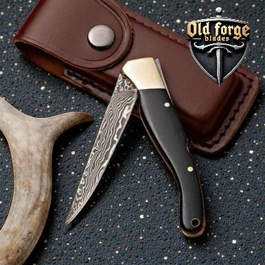 Handmade Damascus steel tactical pocket knife with horn handle and liner lock for everyday carry.
