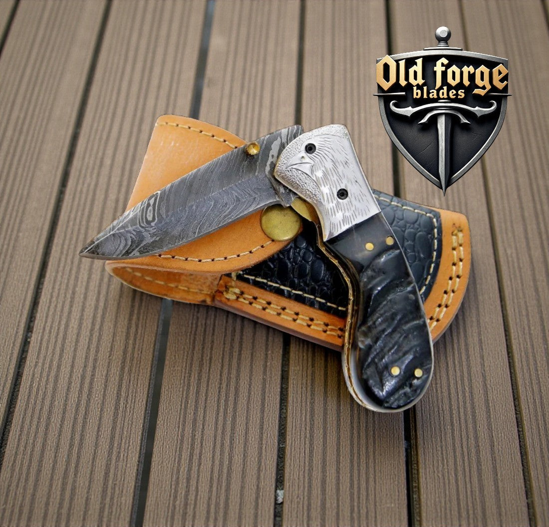 Handcrafted Damascus steel pocket knife with exotic wood and horn handle, engraved bolster, and leather sheath.