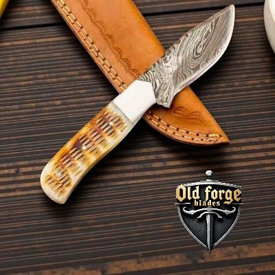 Handmade Damascus steel knife with camel bone handle and leather sheath, perfect for hunting and outdoor use